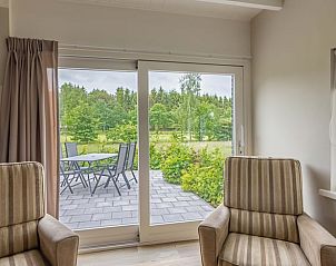 Gezellige binnenruimte van vakantiehuis in Stuifzand, Drenthe, met uitzicht op tuin.