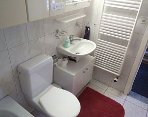 Stijlvolle sanitaire voorzieningen in het Huschen appartement, Winikon, Zwitserland, met moderne wastafel en toilet.