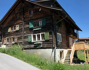 Charmant Huisje in Vignogn, een vakantiehuis in Vignogn, Graubunden, Zwitserland, omgeven door natuur en voorzien van een houten terras.