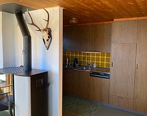 Rustieke charme in de keuken van Huisje in Urmein, vakantiehuis gelegen in Urmein, Graubunden, Zwitserland, met traditionele houtkachel.