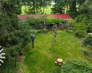 Ingang van DG1780 vakantiewoning in Pesse, Drenthe met groene tuin.