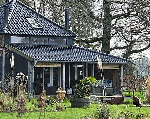 Vakantiehuis DG2027 in Dieverbrug, Zuidwest Drenthe, omgeven door natuur met kunstige metalen vogels in de tuin.