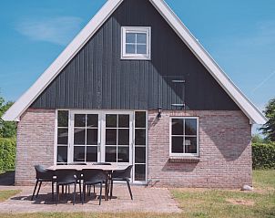 Terrace of Holiday Home Comfortable 8 in Bant, Flevoland overlooking green garden.