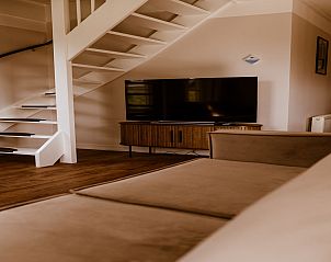 Stylish living room in Holiday Home Comfortable 8 in Bant, Flevoland with modern staircase.
