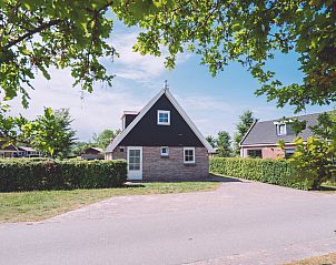 Picturesque street scene at Holiday Home Comfortable 8 in Bant, Flevoland with green surroundings.