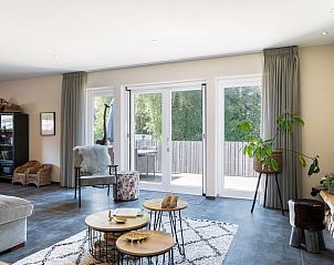 Lichte binnenruimte van Vakantiehuis in Rijs, Friesland, met toegang tot het terras en uitzicht op de natuur.