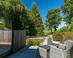 Terras van Vakantiehuis in Rijs, Friesland, met comfortabele zitplaatsen en uitzicht op de natuur.