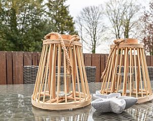 Sfeervol terras in Vakantiehuis in Rijs, Friese bossen, met decoratieve lantaarns en natuurlijke omgeving.