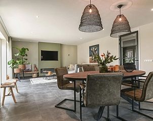 Gezellige eethoek in Vakantiehuis in Rijs, Friesland, met bloemen en sfeervolle decoratie.