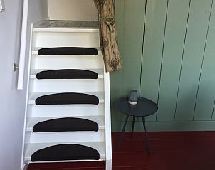 Vakantiehuisje in Harich, trap naar de bovenverdieping, rustiek verblijf in Friesland.