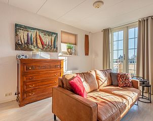 Stijlvolle binnenruimte van Schippershuis Stavoren, een vakantiehuis in Friesland, met kunst aan de muur en sfeervolle inrichting.