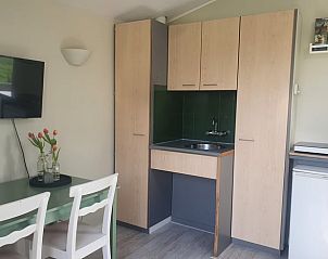 Eethoek en keuken in Vakantiehuisje in Rinsumageast, perfect voor een ontspannen vakantie.