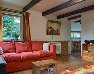 Gezellige zithoek in Vakantiehuis in Oldeholtpade met uitzicht op de natuur.