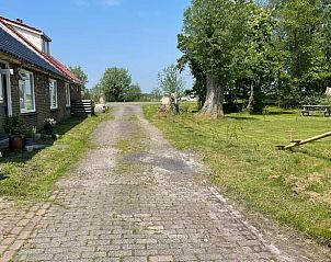 Rustieke oprijlaan naar Huisje in De Westereen, vakantiehuis op het Friese platteland in Friesland, omgeven door groene natuur.