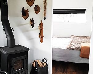 Warm interieur met houtkachel in Vakantiehuis in Kootstertille, Friesland, voor een huiselijk gevoel.