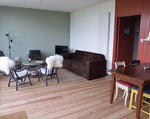 Comfortabele woonkamer in Vakantiehuisje in Munnekeburen, Friesland met houten vloer en gezellige inrichting.