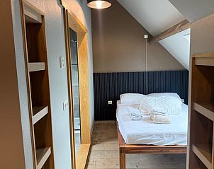 Slaapkamer met houten accenten in Vakantiehuis in Surhuisterveen, rustiek design, Friesland.