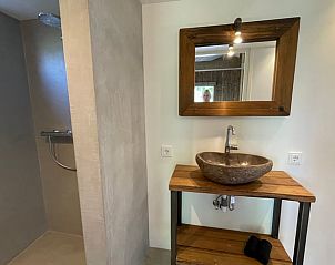 Gerumiges Badezimmer im Ferienhaus Cottage in Gonga mit begehbarer Dusche und Holzdetails.
