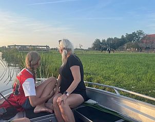 Eine Familie geniet eine Bootsfahrt in der Nhe ihres Ferienhauses in Gonga, Friesland.
