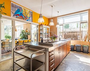 Keuken in Vakantiehuisje in Boksum, Friesland, met roestvrijstalen aanrecht en grote ramen.