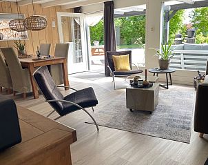 Lichte woonkamer van Vakantiehuisje in Stiens, Friesland, met uitzicht op de groene tuin, ideaal voor ontspanning op het Friese platteland.