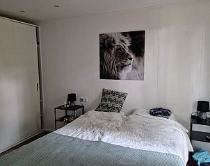 Slaapkamer in chalet In de bosrand Wood 386 Bospark Ede, Ede, Veluwe, met comfortabel bed en moderne inrichting.