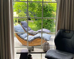 Binnenruimte van Het Veluws Paradijs in Voorthuizen met uitzicht op groene tuin en comfortabele loungeplek.
