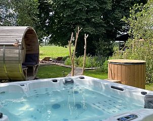 Ontspannen in de jacuzzi van Vakantiehuis in Scherpenzeel, Gelderland, met uitzicht op de groene Veluwe omgeving.