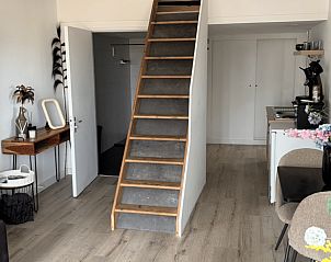 Open living space in Cottage in Uddel, vacation accommodation in Veluwe, Gelderland with stairs and sitting area.