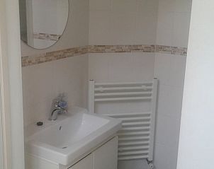 Badkamer met wastafel en spiegel in Vakantiehuisje in De Steeg, Veluwe.