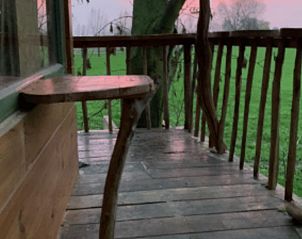 Houten terras bij Vakantiehuis in Nijkerk, Veluwe, Gelderland, met uitzicht op een groene weide.