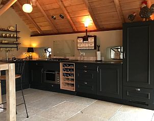 Moderne keuken in Huisje in Oene, Veluwe, Gelderland, met houten balken en sfeervolle verlichting voor een knusse culinaire ervaring.