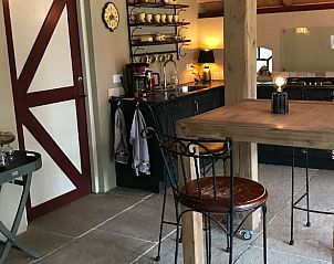 Eettafel en landelijke keuken in vakantiehuis Huisje in Oene, Oene, Veluwe, Gelderland, voor een huiselijke maaltijd.