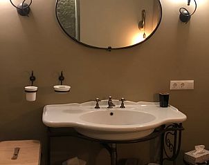 Elegante wastafel in Huisje in Oene, vakantiehuis op de Veluwe, Gelderland, met klassieke spiegel en warme verlichting.