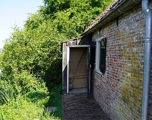 Zijaanzicht van Vakantiehuisje in Hemmen, Veluwe, Gelderland met groene omgeving.