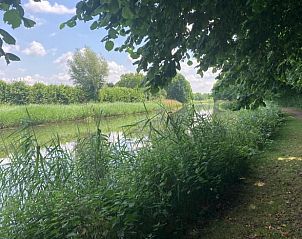 Ontspannen sfeer bij Vakantiehuisje in Hemmen, Veluwe, Gelderland met tuinmeubilair aan het water.