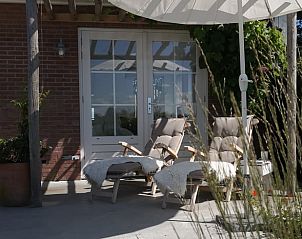 Zonnig terras bij Vakantiehuis in Opende, Zuidwest Groningen met comfortabele ligstoelen