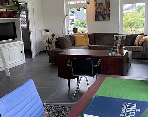 Stijlvolle woonkamer van Vakantiehuis in Midwolde, Zuidwest Groningen, met boekenkast en decoratie.