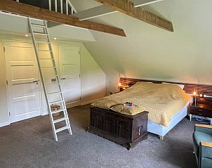 Ruime slaapkamer met houten balken in Vakantiehuis in Midwolde, Zuidwest Groningen.