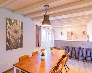 Eetkamer met houten tafel in Koetshuis & Bakhuis vakantiehuis Hoogeloon, nabij de open keuken.