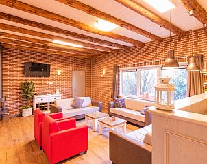 Gezellige woonkamer met open haard in De Hooiberg vakantiehuis, Hoogeloon, Noord Brabant.