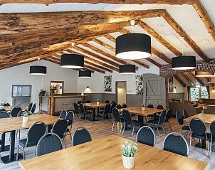 Ruime eetzaal in De Schaapskooi vakantiehuis in Hoogeloon met houten tafels en moderne verlichting, Kempen, Noord Brabant.