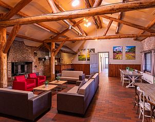 Gezellige binnenruimte in vakantiewoning De Schop, Hoogeloon, met houten balken en comfortabele zithoek in de Kempen, Noord Brabant.