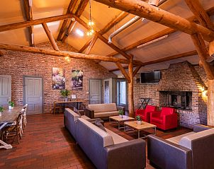 Gezellige binnenruimte van De Schop vakantiehuis in Hoogeloon, Kempen met houten balken en open haard, ideaal voor ontspanning in Noord Brabant.