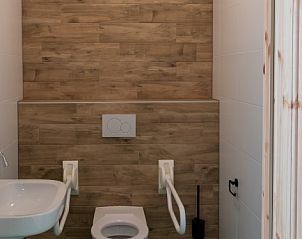 Moderne badkamer in de Kraanvogels vakantieaccommodatie, Tilburg, met toegankelijk design en houten details.