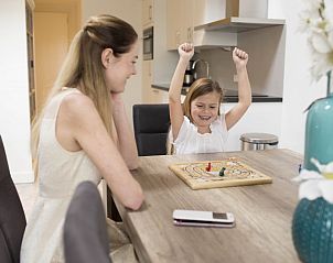 Gezellige eetruimte in De Runsvoort appartement, Helvoirt, waar gezinnen samenkomen voor spelletjes en plezier, gelegen in het hart van Noord Brabant.