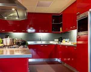 Moderne keuken in De Lummel vakantiehuis in Langenboom, Noordoost Brabant met rode kasten.