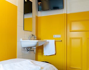 Slaapkamer in De Lummel vakantiehuis in Langenboom, Noordoost Brabant met gele accenten.