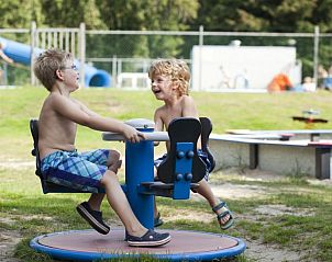 Kinderen spelen in de speeltuin bij De Heidebloem vakantiehuis, Schaijk.