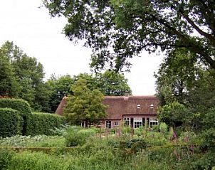 Rustieke tuin bij De Oude Schouten Hofstad vakantiehuis in Gilze, Noord Brabant, met weelderige natuur.